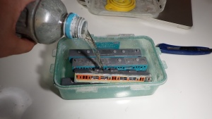 写真は車体の塗装をIPAに浸けて落としている状況